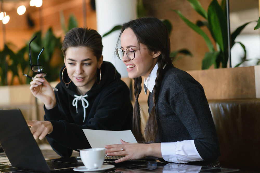 Young professionals in their 20s working on laptops, networking at events, and receiving mentorship, with modern office and digital tools in the background